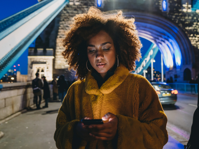 Woman on bridge with phone